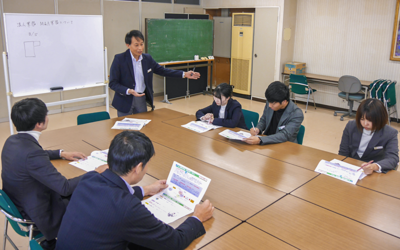 M&A支援の担い手育成へ若手渉外に指導する西川幹二支店長(左から3人目、11月30日、名古屋銀行碧南支店)