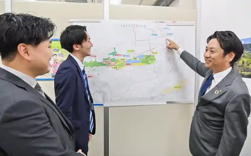小車実史支店長(右)は、渉外担当者と支店独自で作成した菊陽支店周辺の地図を活用しながら情報共有している(11月29日)