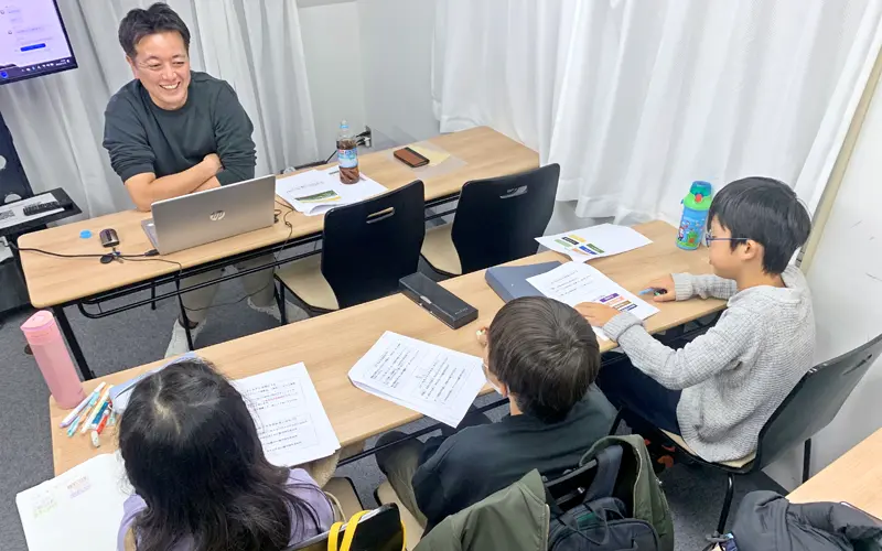 「寺子屋」で小学生に語り掛ける村松一之さん(左上、2023年11月、都内)