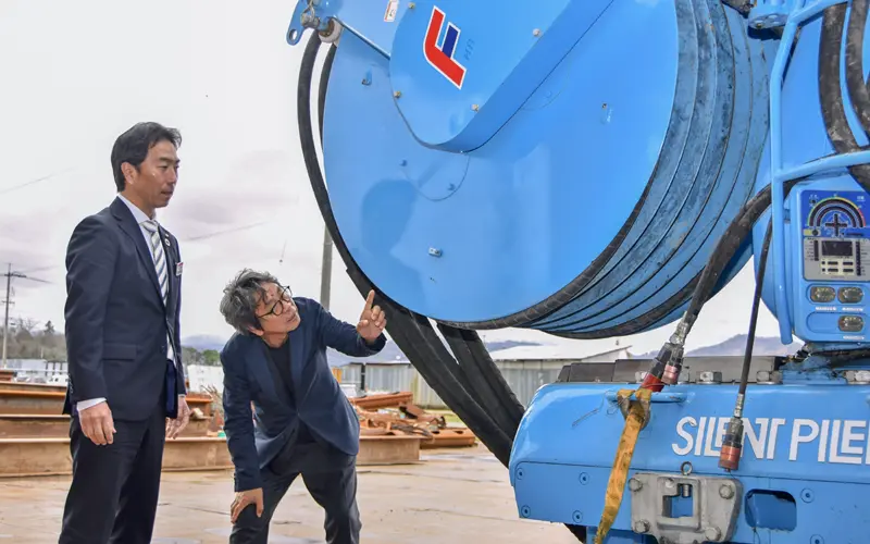 竹内クレーン工業の竹内秀明社長（右）から機材の説明を受ける山根誠一郎部長（２月16日、鳥取市）