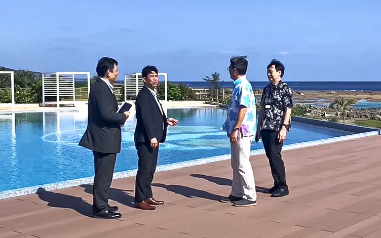 南西楽園リゾートの東郷治人常務(右から2人目)と寶崎克彦統括部長(右)から事業展望について説明を受ける浦崎智支店長(左から2人目)と親泊朝昭副支店長(3月13日、ホテルシギラミラージュビーチフロント、沖縄海邦銀行宮古支店提供)