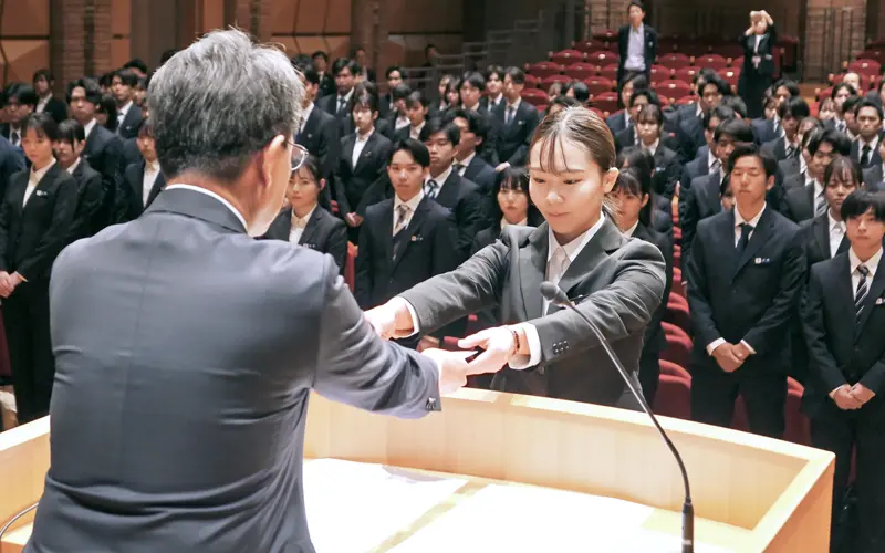 片岡達也・横浜銀行頭取から辞令を受け取る新入社員代表（４月１日、はまぎんホール ヴィアマーレ）