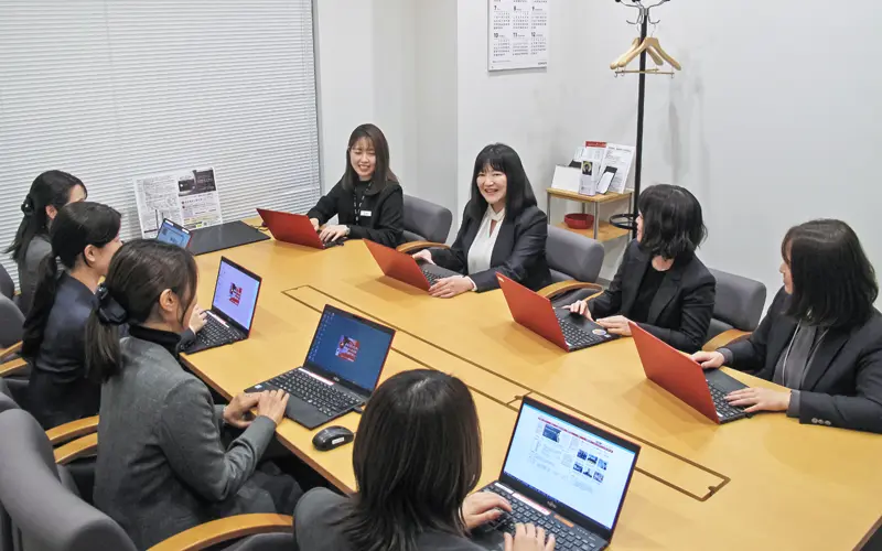 成功例や提案の切り口を気軽に共有し合う八事支店。奥左から2人目が松井利恵支店長(3月26日、三菱UFJ銀行八事支店)