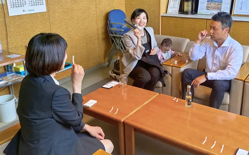 折井茜さん(中央)から試作したサンプルの説明を聞き、香りを嗅ぐ豊和銀行下郡支店の行員(6月11日、豊和銀行下郡支店、豊和銀行提供)