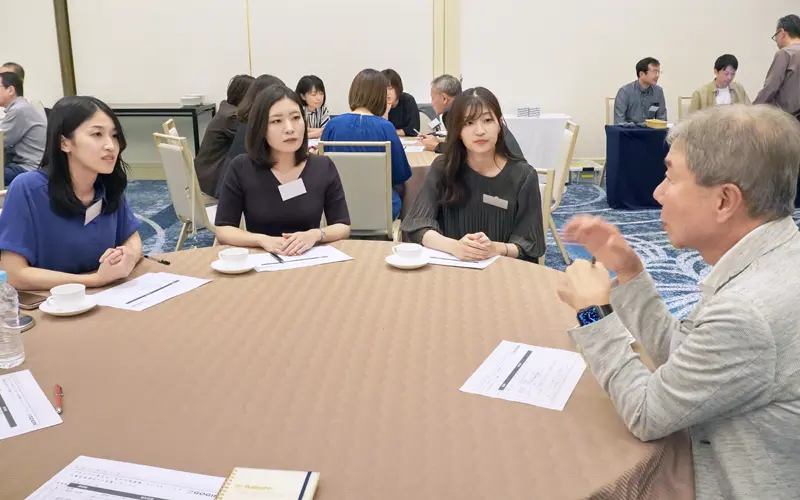 「当行のミライを考える会」で行員と会話する山崎徹頭取(右、山陰合同銀行提供)