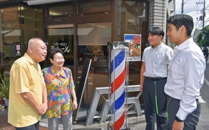 「ヘアーサロン ラムール」の夫妻を訪ねる佐々木崚太係長(右から2人目)と担当者(右、9月11日、東京都世田谷区)