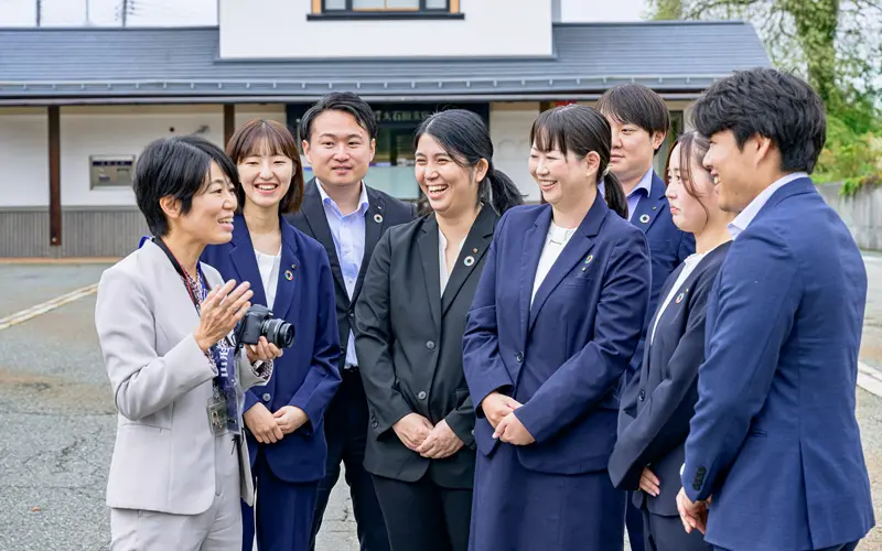 11月号の表紙撮影で訪れた山形銀行大石田支店で行員に取材する中川愛美主任(左、10月9日、山形銀行提供)