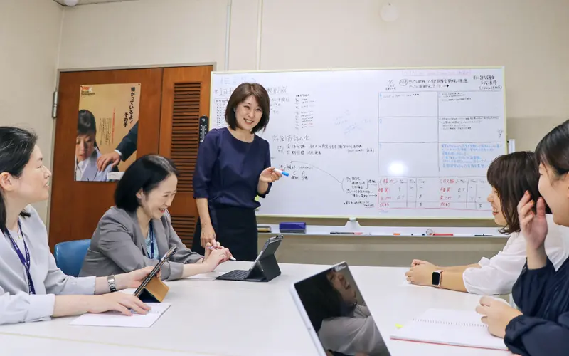 同僚と打ち合わせをする池側聖美支店長(左から3人目、10月23日、福井銀行松島支店)