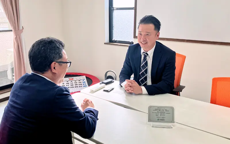 取引先の伊藤邦生・サンアイズ代表取締役（右）と情報交換する浦野元支店長（2024年12月16日、サンアイズ本社）