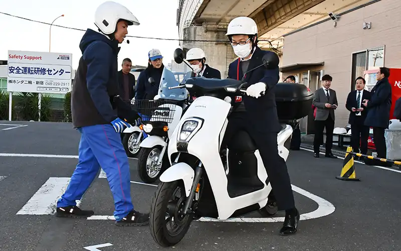 信金中金が三菱オートリースと連携して開いたイベントで、電動バイクを試乗する都内信金職員ら（2月25日）