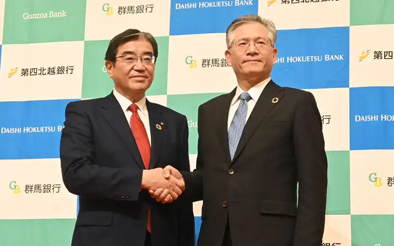 経営統合に踏み切った深井・群馬銀頭取(左)と殖栗・第四北越FG社長(4月24日、オークラ東京)