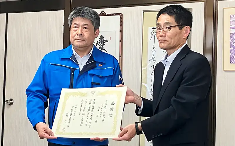 下関商高の校長から感謝状を受け取る前田機工の山本社長(左、5月8日)