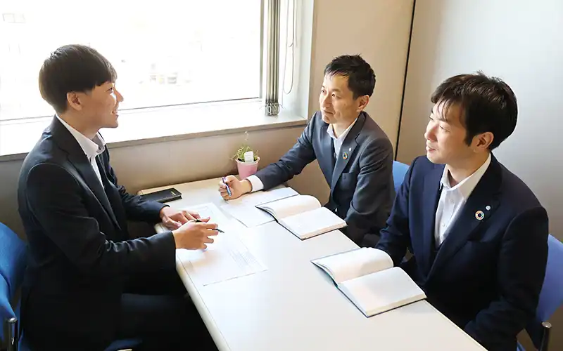 融資先について話し合う(左から)地域サポート部の河井穂高副調査役、吉田諒次長、長尾匡記部長代理(5月13日、本部)