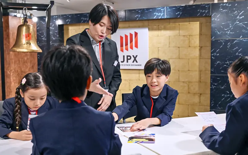 東証パビリオンのメディア向け発表会で上場の手続きを体験する子ども(7月18日、キッザニア東京)