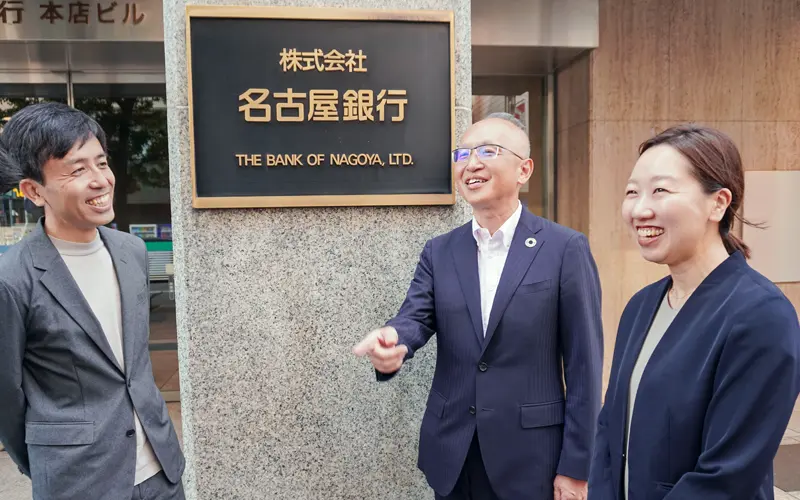 若手・中堅行員とざっくばらんに冗談を言い合う藤原一朗頭取(中央、名古屋銀行本店ビル前)