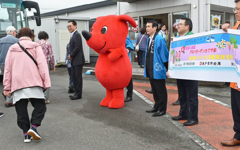 さがみ信金の年金旅行客を、横断幕を掲げ出迎える千葉県5信金の役職員(2024年5月20日、千葉県館山市)