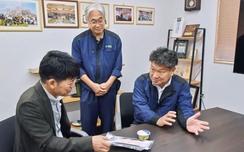 上野慶社長(右)と元岡裕晃常務(同2人目)から商品の特徴を聞く山田裕介支店長(10月6日、上野水産)