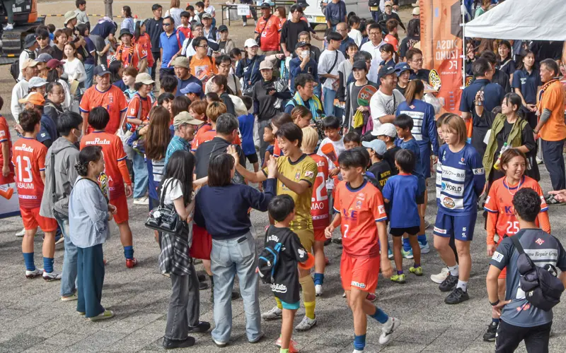 島根銀行サポーティングマッチの勝利をファンと喜び合うディオッサ出雲FCの選手(10月5日、浜山公園陸上競技場)