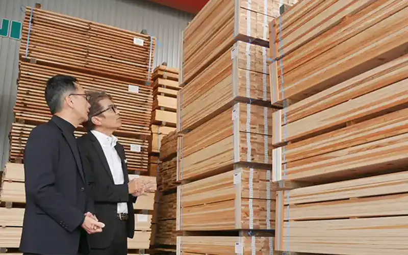 支援先の長瀬光宏社長(右)から製材品の納入先について説明を受ける松島賢治社長(10月21日、徳島県三好市内)
