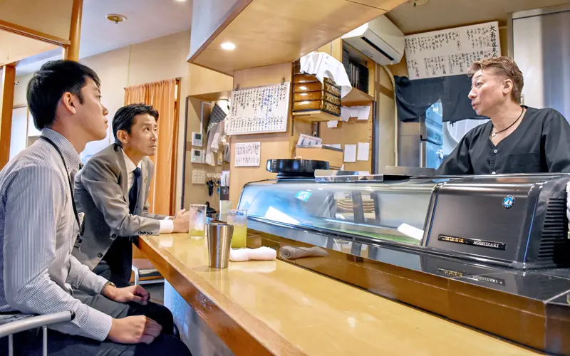 木村和由社長(右)と話す平井貴雄支店長(中央、10月7日、横浜市内)