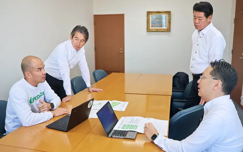 農家の課題について情報交換する中村圭佑・FOODBO・社長(左)と筑邦銀行アグリチームのメンバー(11月12日、本店)