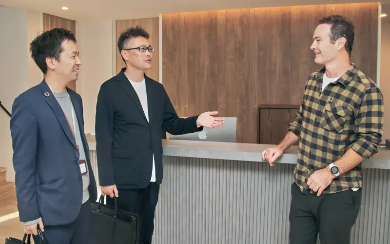 ホリデーニセコを訪問し、アシュリー・ニコルズ代表（右）と情報交換する石田恭太支店長（中央）、融資課の天谷一調査役（10月30日、北海道倶知安町）