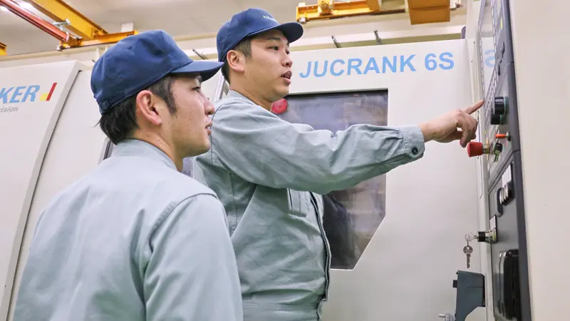 機械の操作方法について話す小金井精機製作所のベトナム人技術者（右、２月４日、埼玉県入間市）