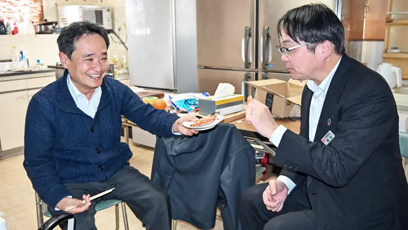 養殖したエビを試食しながら展望について話し合う豊田雄一支店長（右）と藤原敏光さん（２月17日、今治市菊間町）