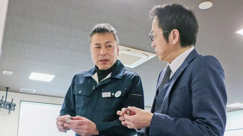 杉村博幸・スギムラ精工社長（左）と話す奥山真司・諏訪信金ビジネスサポート部長（２月18日、長野県岡谷市）