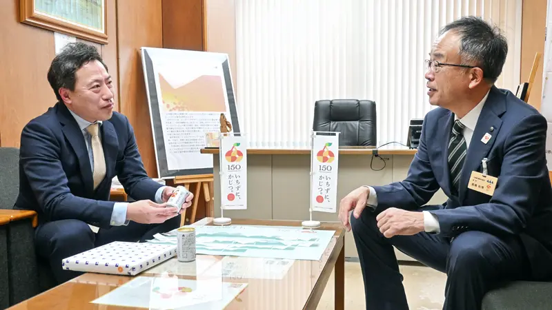 高橋和博・山形県農林水産部長(右)とタイアップ企画について話す宇野泰寛支店長(3月2日、山形銀行県庁支店)