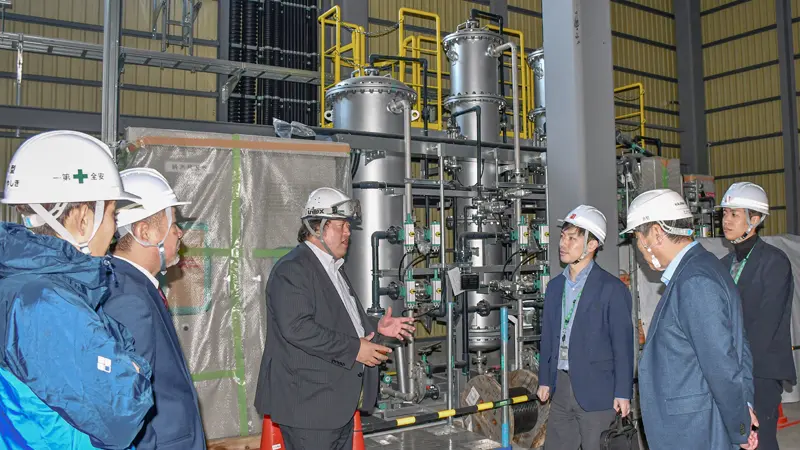 遠藤忠寿・八幡平ネクストエナジー社長(左から3人目)から木質バイオマス発電所の設備について説明を受ける小松正人支店長代理(同4人目)、結城公博支店長(同5人目)、担当者(同6人目、3月24日、八幡平市)