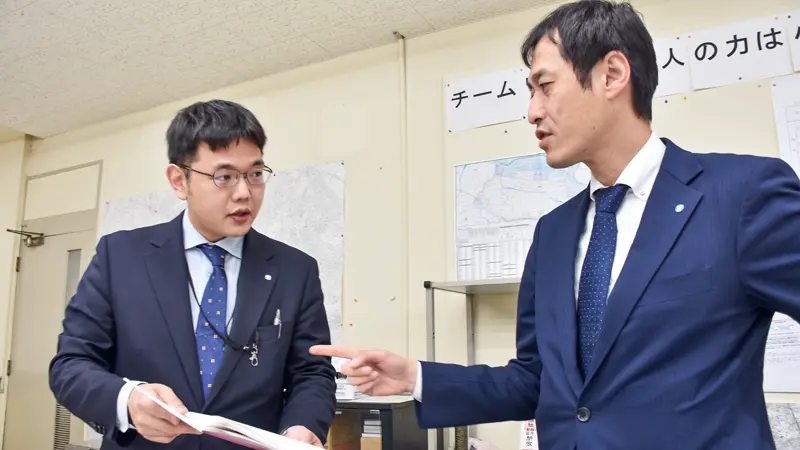 ノートを見ながら話し合う担当者（左）と林孝司支店長（４月22日、東京信金大山支店）