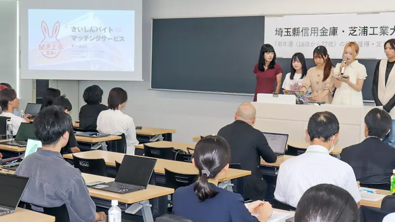 プレゼンする学生に耳を傾ける埼玉県信金職員（７月24日、芝浦工業大）