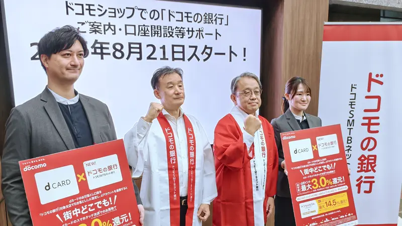 ドコモショップでの銀行口座開設支援の開始を発表した廣井孝史・ドコモFG社長(右から2人目)と円山法昭・ドコモSMTBネット銀行社長(同3人目)ら(8月21日、ドコモショップ丸の内店)