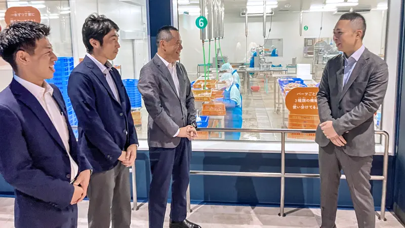 かにファクトリー内で談笑する中野圭昌支店長(左から3人目)杉坂昌紀副支店長(同2人目、現・舞鶴中央支店長)、瀧ケ花亮祐主任(左)と増田学専務(9月9日、敦賀市)