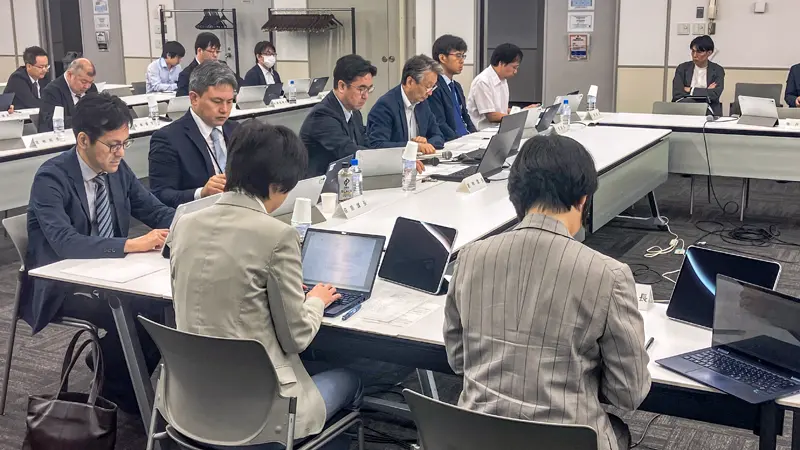 社会保障審議会の部会で後期高齢者医療制度での金融所得反映スキームを報告する厚労省幹部(10月16日、東京都港区)